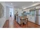 Dining room with hardwood floors, and view into updated kitchen with white cabinetry and stainless steel appliances at 10 Humphrey Ct, Charleston, SC 29403