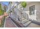 Stairway and entrance to a white home, complemented by lush greenery and a brick walkway at 10 Humphrey Ct, Charleston, SC 29403