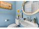 Powder room with a white pedestal sink, gold mirror, and light blue walls at 1008 Hoodtown Rd, Bonneau, SC 29431