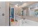 Well-lit bathroom featuring a jetted tub, vanity, and tiled walls and floors at 1008 Hoodtown Rd, Bonneau, SC 29431