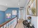Upstairs hallway with light wood flooring and beautiful artwork at 1008 Hoodtown Rd, Bonneau, SC 29431