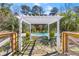 Inviting backyard pool with a pergola, palm trees and charming wooden fence at 1008 Hoodtown Rd, Bonneau, SC 29431