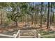 Backyard vista highlighting a secluded patio area with an outdoor table and chairs in a wooded setting at 1014 Bradbury Ln, Charleston, SC 29492