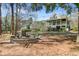 Picturesque backyard featuring a charming house, lovely landscaping, and a cozy stone fire pit at 1014 Bradbury Ln, Charleston, SC 29492