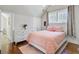 Inviting bedroom featuring a double bed, two windows, pink accents and wood floors at 1014 Bradbury Ln, Charleston, SC 29492