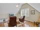 Bright bonus room with hardwood floors, TV and two leather chairs under a slanted ceiling at 1014 Bradbury Ln, Charleston, SC 29492