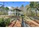 Stunning two-story home with a spacious porch and well-manicured lawn surrounded by mature trees at 1014 Bradbury Ln, Charleston, SC 29492