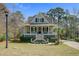 Charming home featuring a welcoming front porch with a manicured lawn and mature trees at 1014 Bradbury Ln, Charleston, SC 29492