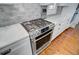 Close up of stainless steel gas range with white marble countertop and subway tile backsplash at 1014 Bradbury Ln, Charleston, SC 29492