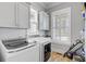 Well-lit laundry room with modern machines, built-in cabinets, and a window at 1014 Bradbury Ln, Charleston, SC 29492