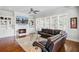 Comfortable living room with a fireplace, large windows, and a cozy leather sofa at 1014 Bradbury Ln, Charleston, SC 29492