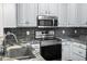 Clean, stainless steel appliances complement the granite countertops and tile backsplash in this modern kitchen at 1025 Riverland Woods Pl # 609, Charleston, SC 29412