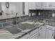 Close up of a kitchen sink featuring elegant countertops, gray cabinets, and modern fixtures at 1025 Riverland Woods Pl # 609, Charleston, SC 29412
