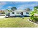Charming white bungalow with a well-manicured lawn and tropical landscaping at 1077 Harbor View Rd, Charleston, SC 29412
