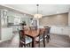 Inviting dining room with a wooden table set for eight, showcasing modern lighting and seamless flow to the kitchen at 115 Clubhouse Rd, Summerville, SC 29483