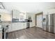 Well-lit kitchen showcases stainless steel appliances, white cabinetry, granite countertops, and luxury vinyl plank flooring at 115 Clubhouse Rd, Summerville, SC 29483