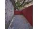 Red privacy fence on a gravel side yard to a brick home exterior at 115 Clubhouse Rd, Summerville, SC 29483