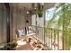 The balcony has a wood swing, tile floors, plants, and a partial view of the outside at 1158 Village Creek Ln # 3, Mount Pleasant, SC 29464