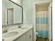 Bright bathroom with double sinks, granite countertops and a shower with blue striped curtain at 116 Rouen Ln, Summerville, SC 29486