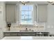 Bright kitchen features white countertops and backsplash, with views of a pond through the window at 116 Rouen Ln, Summerville, SC 29486