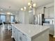 Modern kitchen island with white quartz countertops, pendant lights, stainless appliances, and hardwood floors at 116 Rouen Ln, Summerville, SC 29486
