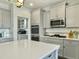 Open kitchen with gray cabinetry, stainless steel appliances and a large white countertop island at 116 Rouen Ln, Summerville, SC 29486