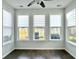 Bright sun room with many windows showcasing outside view, ceiling fan, and dark floors at 116 Rouen Ln, Summerville, SC 29486
