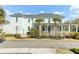 Inviting home exterior with a covered front porch, manicured lawn, and mature palm trees at 1429 Lettered Olive Ln, Mount Pleasant, SC 29464