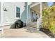 Charming light blue home exterior featuring a patio and stairs leading to a covered porch at 1429 Lettered Olive Ln, Mount Pleasant, SC 29464
