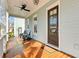 Beautiful front porch with dark wood flooring, ceiling fan, and comfortable seating to enjoy the outdoors at 1429 Lettered Olive Ln, Mount Pleasant, SC 29464