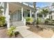 Inviting front porch with white columns, ceiling fans, and a glimpse of the neighboring homes in the community at 1429 Lettered Olive Ln, Mount Pleasant, SC 29464