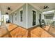 Expansive front porch with rich wood flooring, ceiling fans, and comfortable seating for relaxing outdoors at 1429 Lettered Olive Ln, Mount Pleasant, SC 29464