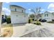 A two-car garage with a concrete driveway leading to a light blue home at 1429 Lettered Olive Ln, Mount Pleasant, SC 29464