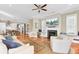Open-concept living room with a fireplace, hardwood floors, open to the dining room and kitchen at 1429 Lettered Olive Ln, Mount Pleasant, SC 29464