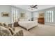 Bright main bedroom features neutral decor, ceiling fan, and large windows with plantation blinds at 1429 Lettered Olive Ln, Mount Pleasant, SC 29464