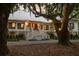 Stunning exterior view showcasing the charming home with mature trees, inviting front porch, and well-manicured landscaping at 1456 Mcpherson Lndg, Johns Island, SC 29455