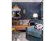 Stylish living room features a leather sofa, blue chair, and ornate gold mirror against a dark blue accent wall at 1456 Mcpherson Lndg, Johns Island, SC 29455