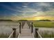 Picturesque view of a wooden pier stretching over the marsh at sunset at 1456 Mcpherson Lndg, Johns Island, SC 29455