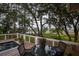 Inviting deck area with a pool, hot tub, and outdoor dining, all surrounded by lush trees at 1456 Mcpherson Lndg, Johns Island, SC 29455