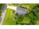 Aerial view of a landscaped backyard with firepit and home with a gray roof, driveway, and green grass at 1617 Southwick Dr, Johns Island, SC 29455