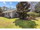 Spacious backyard with lush green grass, mature trees, and the home's exterior with neutral siding and windows at 1617 Southwick Dr, Johns Island, SC 29455