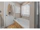 Bathroom featuring a soaking tub with ceramic tile surround, linen curtains, and a modern art piece at 1617 Southwick Dr, Johns Island, SC 29455