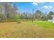 Spacious backyard featuring lush greenery, a fire pit, and a shed, providing an ideal setting for outdoor relaxation and entertainment at 1644 Cooper Store Rd, Moncks Corner, SC 29461