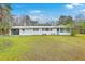 Charming single-story home featuring a spacious lawn, white siding, an open garage, and classic curb appeal at 1644 Cooper Store Rd, Moncks Corner, SC 29461