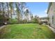 Expansive backyard with a wooden fence, lush greenery, and a covered patio at 166 Pavilion St, Summerville, SC 29483