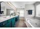 Modern bathroom featuring dual sinks, vanity, soaking tub, and ample lighting at 166 Pavilion St, Summerville, SC 29483