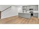 Bright and airy living room with modern kitchen, open staircase, and natural hardwood floors at 169 Cantona Dr, Summerville, SC 29483