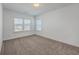 An empty bedroom with neutral carpet and two windows providing natural light at 175 Darby Meadow Ln, Ridgeville, SC 29472