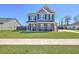 Charming two-story home with a lush green lawn, blue siding, and stone accents, creating curb appeal at 175 Darby Meadow Ln, Ridgeville, SC 29472