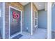 Inviting front entry with a black door, stone accents, and an amusing red dragon wreath at 175 Darby Meadow Ln, Ridgeville, SC 29472